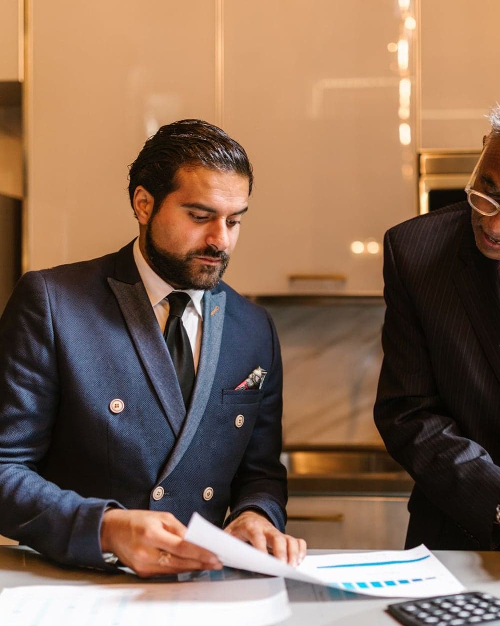 Two professionals reviewing coverage paperwork together at a kitchen counter
