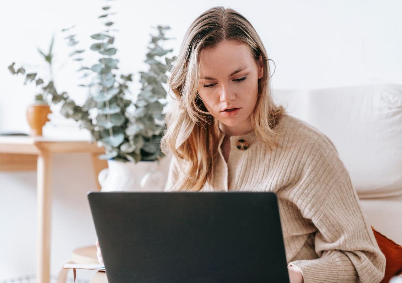 A young woman working on a laptop at home