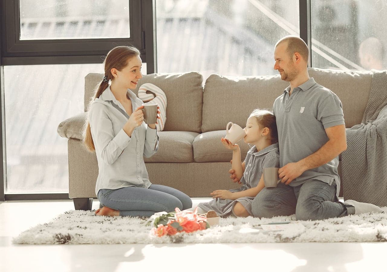 A family relaxing together on their living-room floor at home